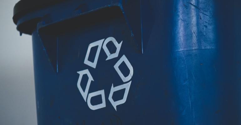 Closed blue rubbish bin with a white recycling sign on it