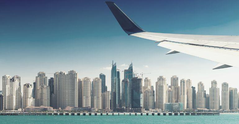 Plane flying over dubai skyline