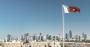 Bahrain glag with skyline of Manama at Bahrain Fort with blue sky.jpg